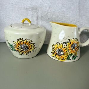 Speckled ceramic pitcher and creamer features a hand-painted sunflower design